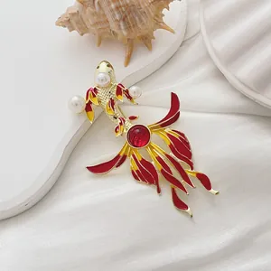 Makro-Detail der Koi-Brosche mit roter Emaille und Perlenakzenten auf weißer Seide