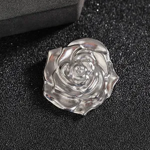 Macro shot of silver rose brooch featuring intricate layered petals and metallic finish