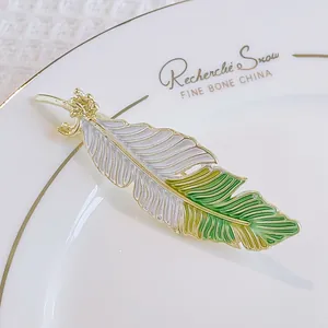 Detailaufnahme einer eleganten Federbrosche mit vergoldeter grüner Emaille-Verlauf