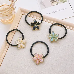 Détail de quatre chouchous fleurs élastiques avec strass aux couleurs pastel