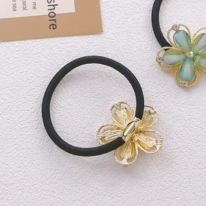 Vue détaillée d'élastiques fleurs avec pétales dorés et résine verte sertie de strass