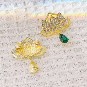 Front and back view of gold lotus brooch with green crystal pendant and rhinestones