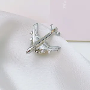 Detailed macro view of silver airplane brooch with window textures on silk fabric