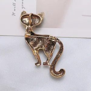 Back view of vintage gold cat brooch with crystal showing metallic texture and pin clasp