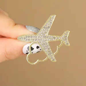 Broche avion dorée avec strass scintillants et détail de queue en forme de petit cœur