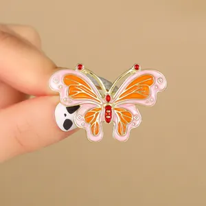 Exquisito broche de mariposa con esmalte rosa y naranja y piedras rojas brillantes
