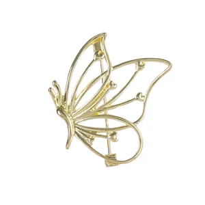 Broche papillon dorée minimaliste avec détails en cœur sur fond blanc épuré