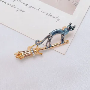 Macro detail of blue enamel cat on a golden broom pin with sparkling rhinestones