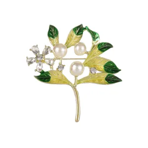 Vintage gold brooch with green enamel leaves, white pearls and sparkling crystal flowers