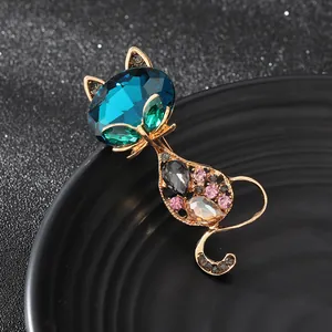 Luxury gold cat brooch featuring a deep blue sapphire head and multi-color crystal body