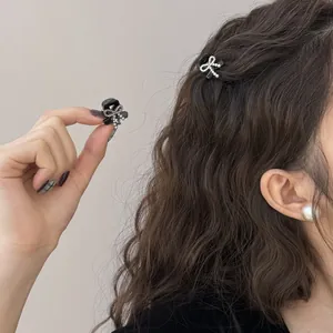 Elegant mini black hair claws with rhinestone bow design for half-up hairstyles