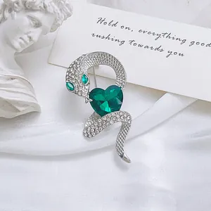 Luxury silver snake brooch with emerald heart crystal and sparkling pavé diamonds