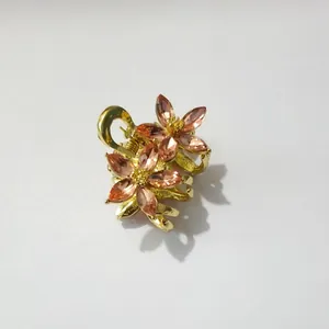 Détail d'une petite pince à cheveux fleur dorée avec cristaux de couleur champagne