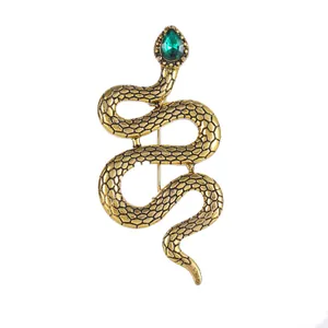 Vintage golden snake brooch with green teardrop crystal and textured metal scales
