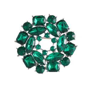 Luxurious green crystal round brooch with emerald-cut stones and silver metal base