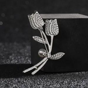 Elegant silver tulip brooch with a white pearl and textured finish on a dark background