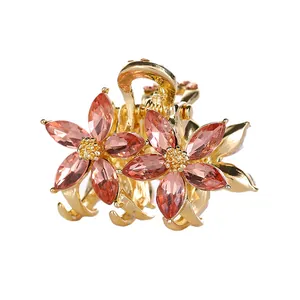 Pince à cheveux fleurie dorée avec cristaux roses sur fond blanc impeccable