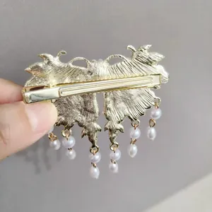 Pinza para el pelo de mariposa dorada con borlas de perlas blancas y detalles de nubes