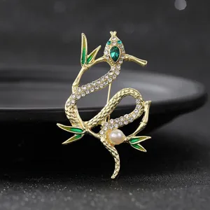 Broche serpent et feuille de bambou exquise plaquée or avec strass blancs et émail vert