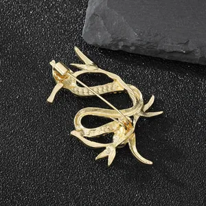 Broche dragon dorée exquise avec texture mate et épingle de sûreté sur fond de pierre noire