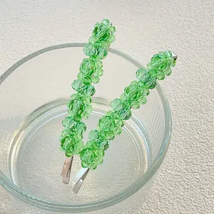 Elegant green crystal hair clips set with silver metal base on glass decoration