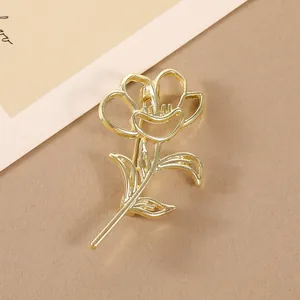 Vue macro d'une broche rose dorée évidée avec texture métallique sur fond neutre
