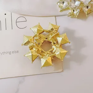Back view of gold geometric starburst brooch showing pin fastener and brushed metal texture