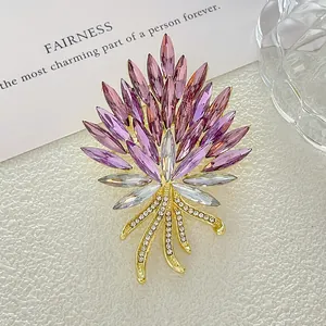 Detalle de broche floral con cristales violetas y tallo dorado con pedrería brillante
