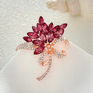 Primer plano de un broche de flor en oro rosa con cristales magenta y strass brillante