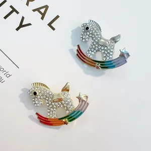 Elegant gold and silver rocking horse brooches with rainbow base and sparkling rhinestones