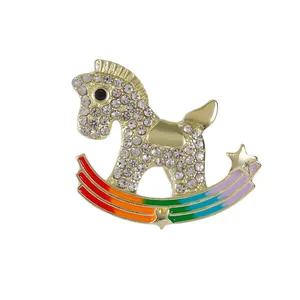 Sparkling gold rocking horse brooch with colorful rainbow base and inlaid rhinestones