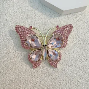 Detail einer goldenen Schmetterlingsbrosche mit funkelnden rosa Strasssteinen