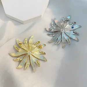 Elegante Sonnenblumen-Brosche in Gold und Silber mit feiner Textur auf weißem Seidenstoff
