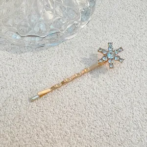 Detailaufnahme einer goldenen Schneeflocken-Haarklammer mit glänzenden Strasssteinen