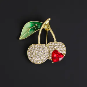 Elegant cherry brooch with sparkling rhinestones and red heart gem on black background