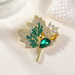Broche luxueuse en forme de feuille d'érable avec strass verts et jaunes sur fond blanc