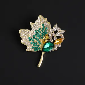 Élégante broche feuille d'érable avec strass verts et alliage doré sur fond noir