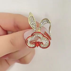 Broche lapin dorée chic avec cristaux blancs, cœur rouge et motifs de nuages chinois