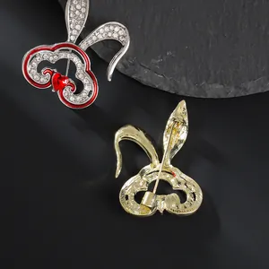 Broche lapin en forme de cœur avec cristaux blancs et émail rouge sur une pierre noire