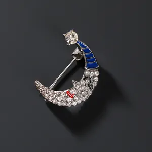 Smiling crescent moon brooch with blue enamel hat and white rhinestones on silver metal