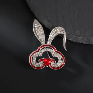 Vue macro de broche lapin avec cristaux blancs et pierre précieuse rouge en cœur