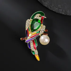 Detailed view of colorful enamel parrot brooch with green gemstone and pearl detail