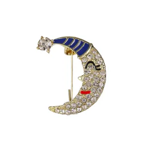Smiling crescent moon brooch with sparkling rhinestones and a blue striped nightcap charm