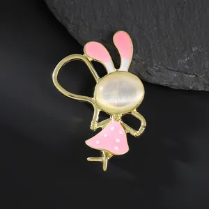 Broche lapin mignonne avec pierre œil de chat et détails émail sur un rocher noir