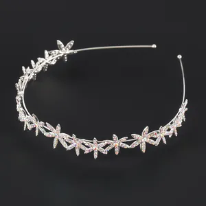 Cerchietto floreale in metallo argento con strass cangianti su sfondo nero minimal