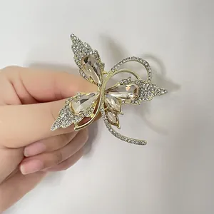Broche papillon dorée élégante ornée de cristaux étincelants et accents couleur champagne