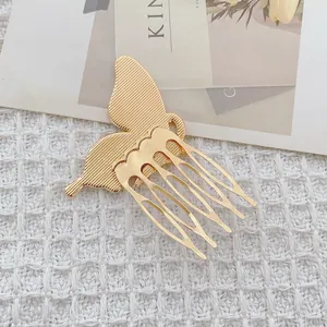Golden butterfly hair comb with a 5-tooth metal pin on a white textured background
