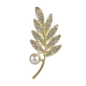 Élégante broche en forme de feuille dorée avec zircons brillants et une perle blanche