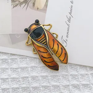 Vintage cicada brooch in golden zinc alloy with orange enamel on elegant card