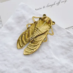 Vintage gold-plated cicada insect brooch with detailed brushed texture and pin fastener